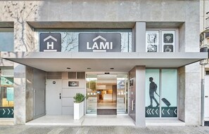 A modern hotel entrance with a reception desk, a sign indicating a hotel, and a digital display. - Hostal Lami (Esplugues de Llobregat)