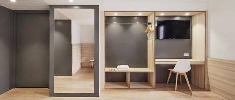 Una habitación de hotel moderna con una cama, un escritorio y un televisor.