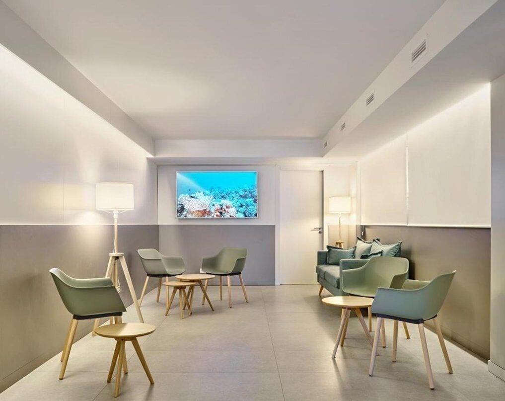 Ein modernes Hotelzimmer mit Sitzecke, Fernseher und großem Fenster.