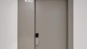 Uma porta fechada com um cadeado de teclado numérico e o número '106' visível na parede.