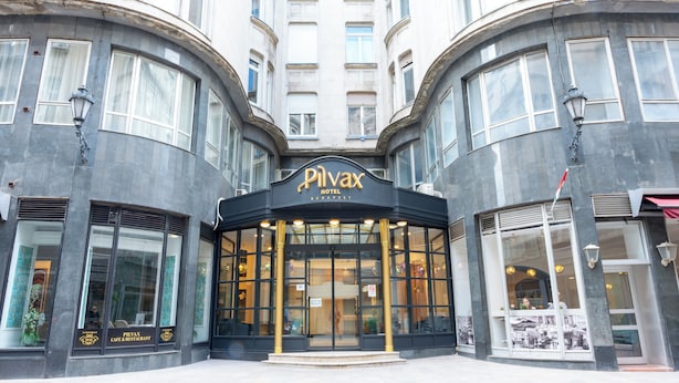 A hotel entrance with a curved facade, large windows, and a prominent sign. - Pilvax Hotel Budapest (Budapest)