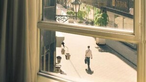 A window with a view of a street, buildings, and a bank. - Pilvax Hotel Budapest (Budapest)