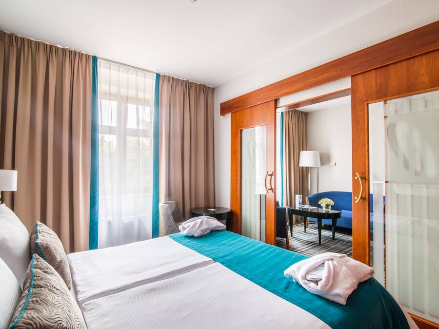 Ein Hotelzimmer mit einem großen Bett, einem Schreibtisch, einem Stuhl und einem Kleiderschrank.