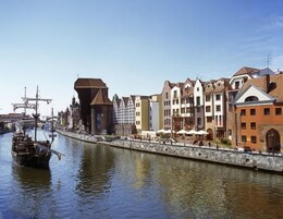 A canal with historic buildings and a ship.