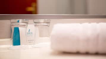 Ein Badezimmer-Waschtisch mit Handtuch, Duschhaube und einer Shampoo-Flasche.