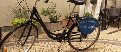 Un vélo portant une pancarte bleue sur laquelle sont affichés les logos d’hôtels.