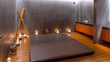 Experience a serene spa retreat with a massage table, wooden bench, and candlelit ambiance.