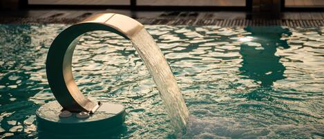 Un élément décoratif aquatique avec un bec courbé, installé dans un espace piscine.