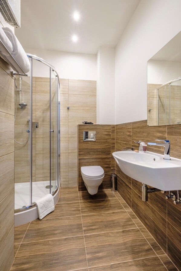 A modern bathroom with a glass-enclosed shower, a white sink, and a toilet. - Hotel Reytan (Warsaw)