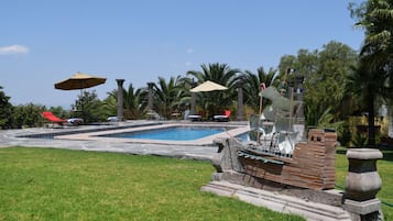 Alberca al aire libre y camastros