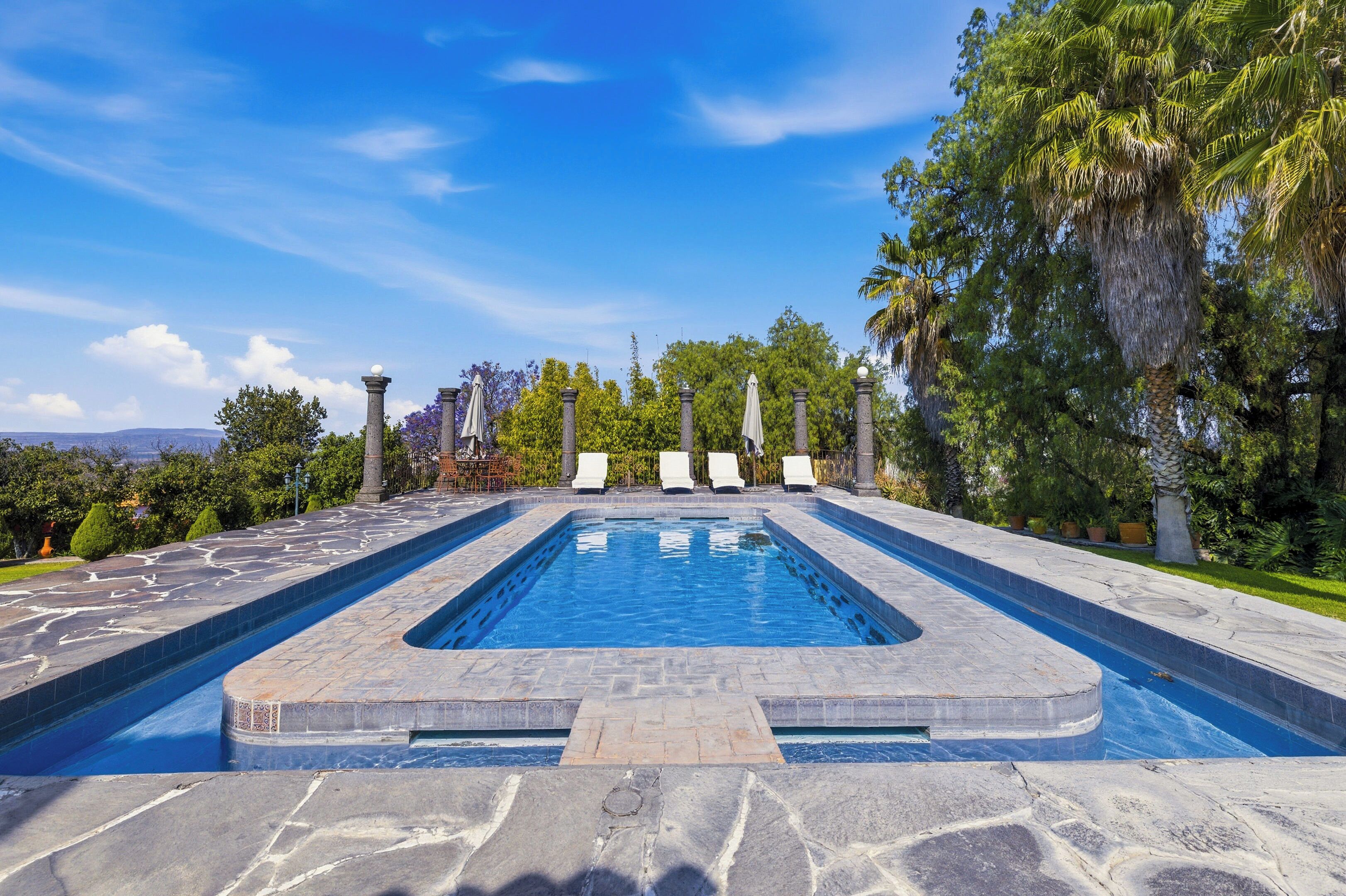 Een buitenzwembad en ligstoelen