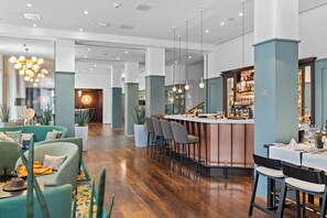 Relax in our spacious lobby, featuring a central bar, seating area, and reception desk.