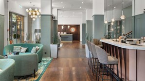 Un intérieur moderne avec un bar, des sièges et une cuisine en arrière-plan.