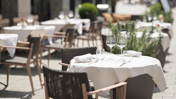 A restaurant with outdoor seating, white tablecloths, and neatly arranged chairs. - Residence Hotel (Vaduz)