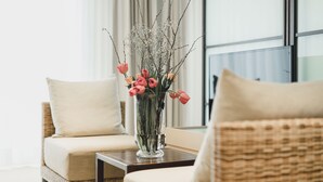 A living room with a sofa, a coffee table, and a vase with flowers. - Residence Hotel (Vaduz)