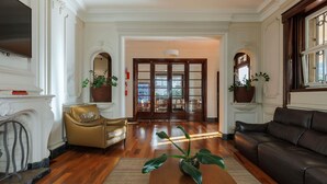 A spacious living room with a fireplace, leather sofas, a coffee table, and potted plants. - Ibis Belo Horizonte Liberdade (Belo Horizonte)