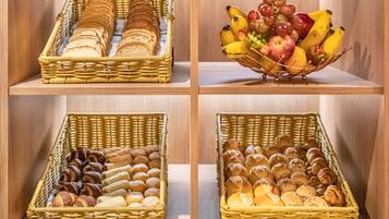 Four wicker baskets on shelves containing bread, pastries, and a fruit bowl.