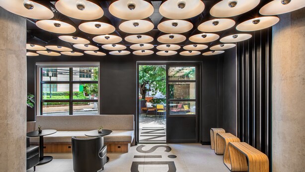 Un interior moderno con una zona de estar, un ventanal grande y un diseño de techo único.