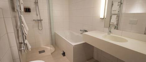 A modern bathroom with a glass-enclosed shower, a standalone bathtub, a toilet, and a vanity with a sink.