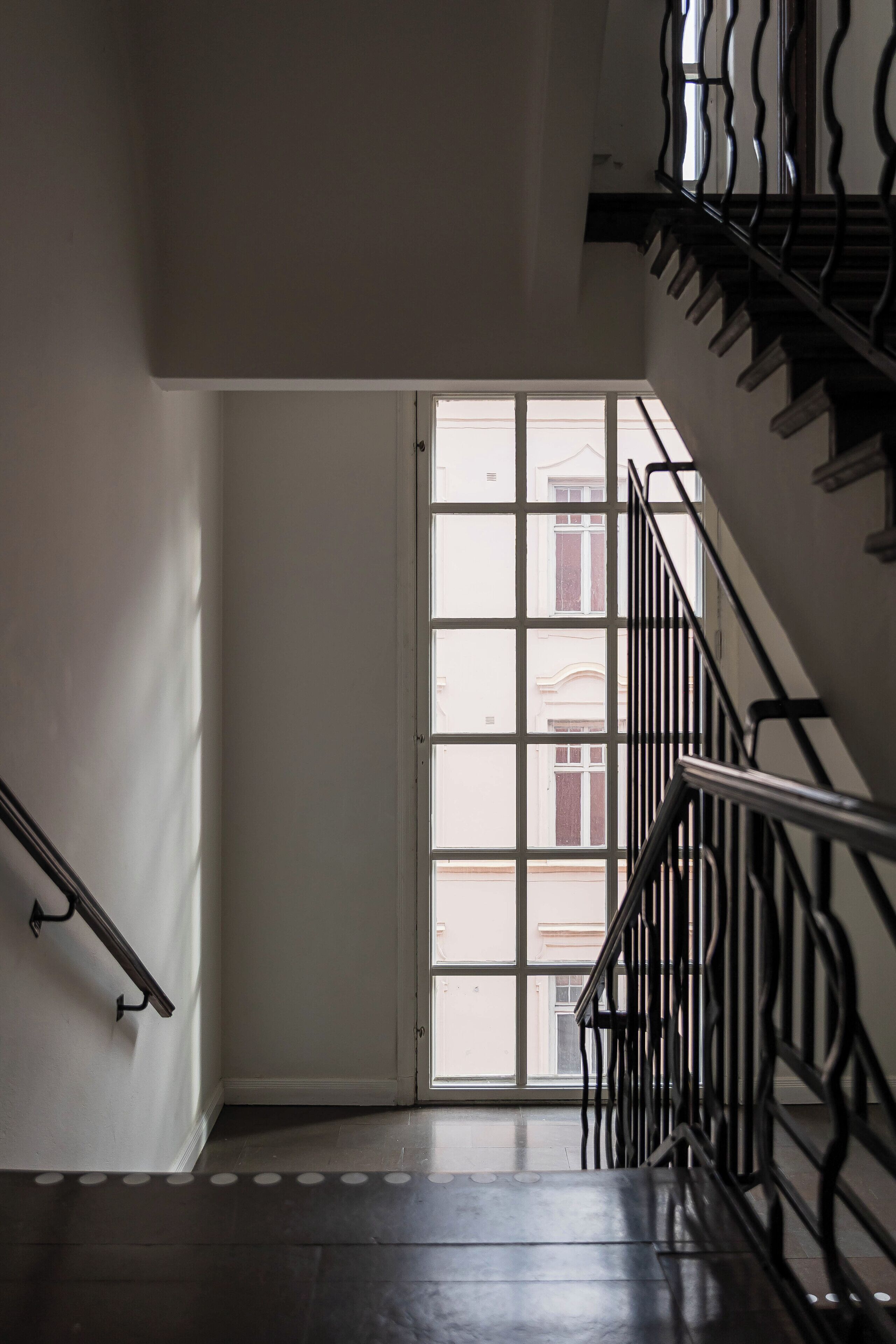 A staircase with a metal railing leading to a door with a window.