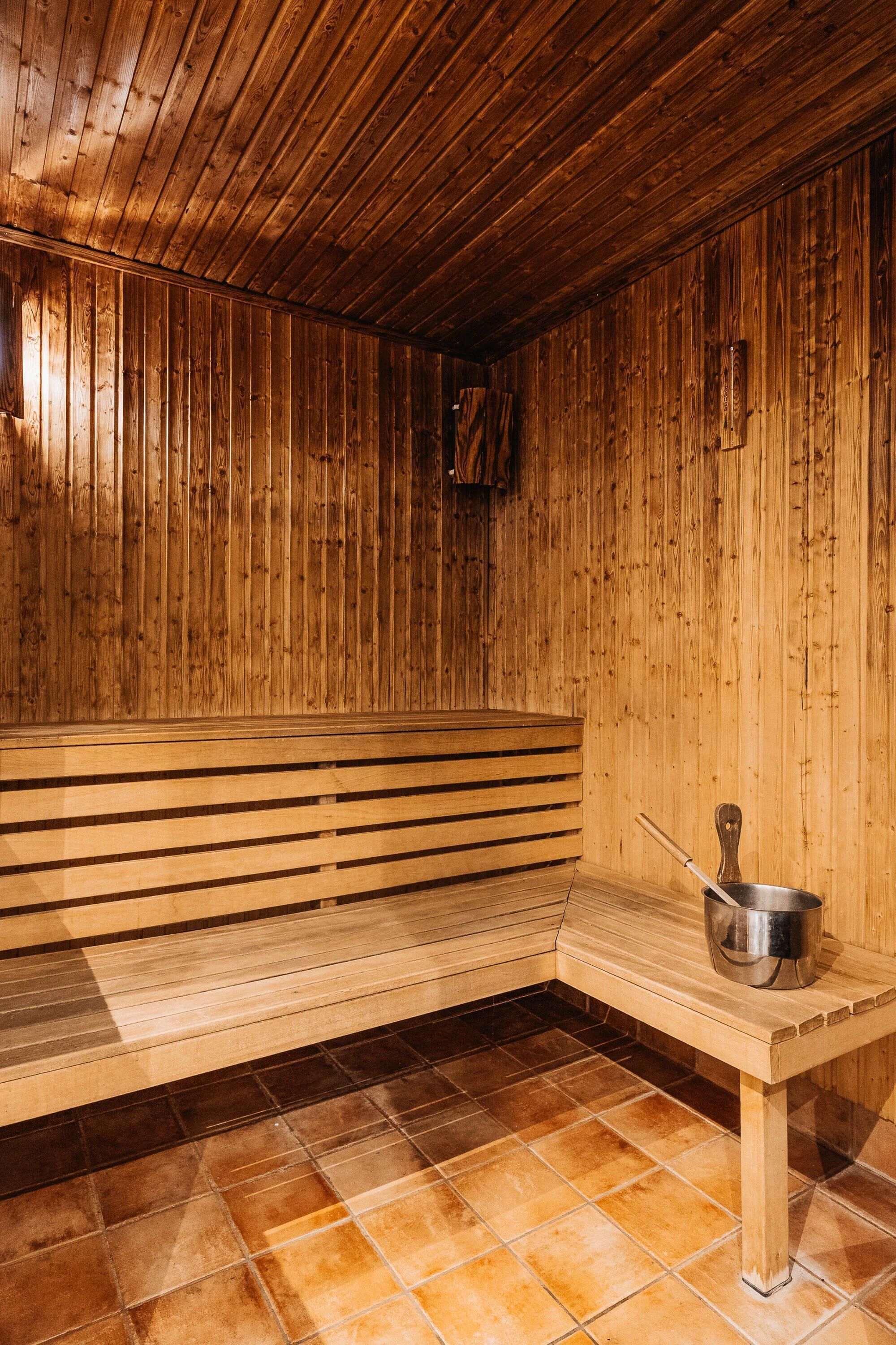 Una sauna de madera con bancos y una mesa.