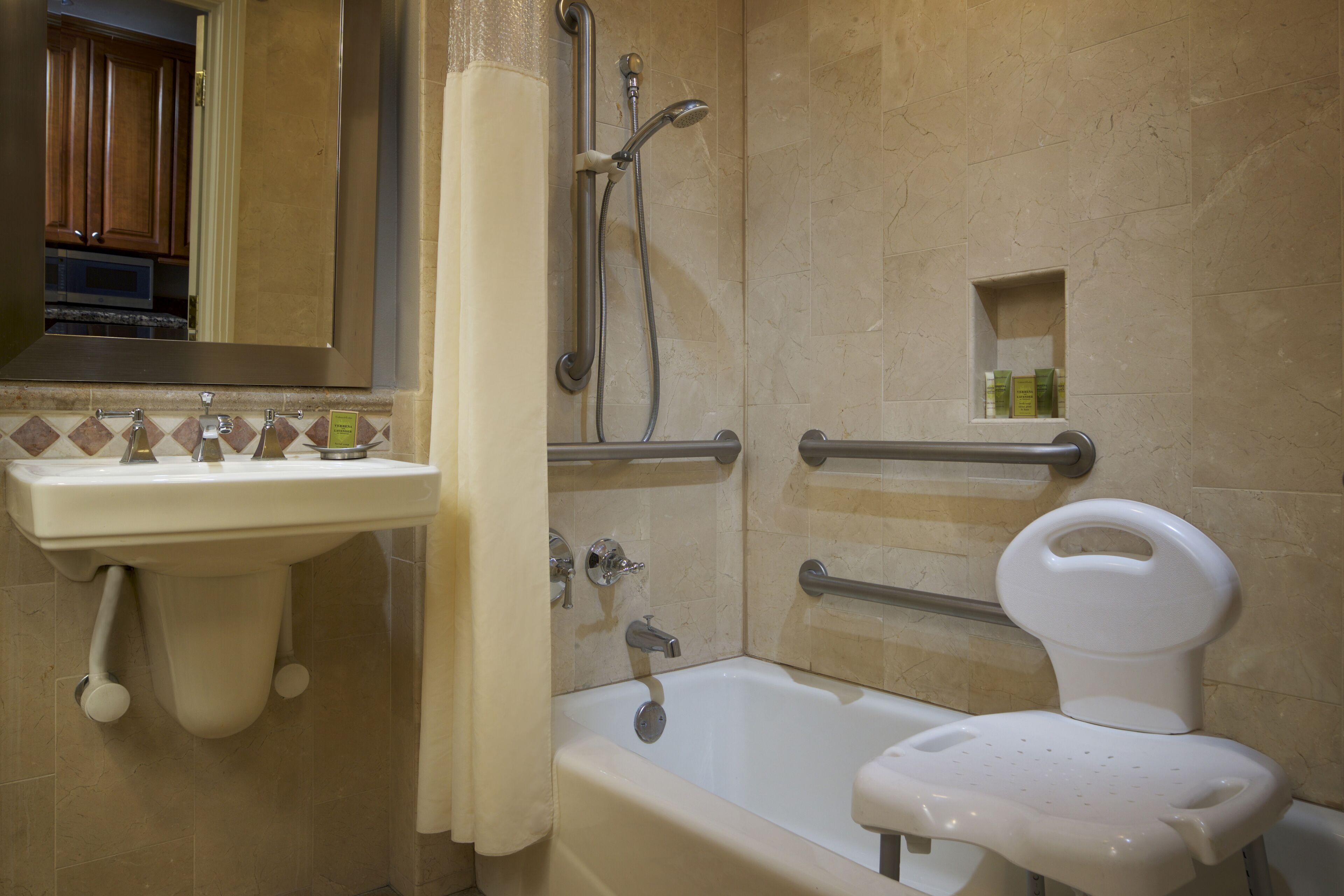 Et badeværelse med vask, badekar, brusebad og toilet.