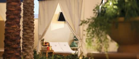 Alojamiento con carpa, una cama, una mesa pequeña con frutas y una taza, y una ventana.