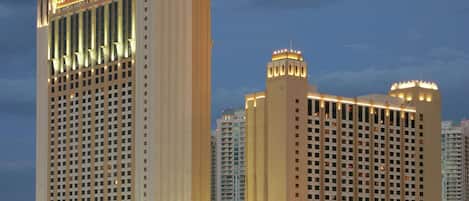 A high-rise hotel with multiple floors, large windows, and a prominent entrance area.