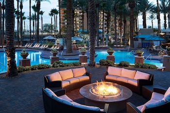 A spacious hotel lobby with a central column displaying directional signs, a fitness center, and a membership experience area. at Hilton Grand Vacations Club on the Las Vegas Strip