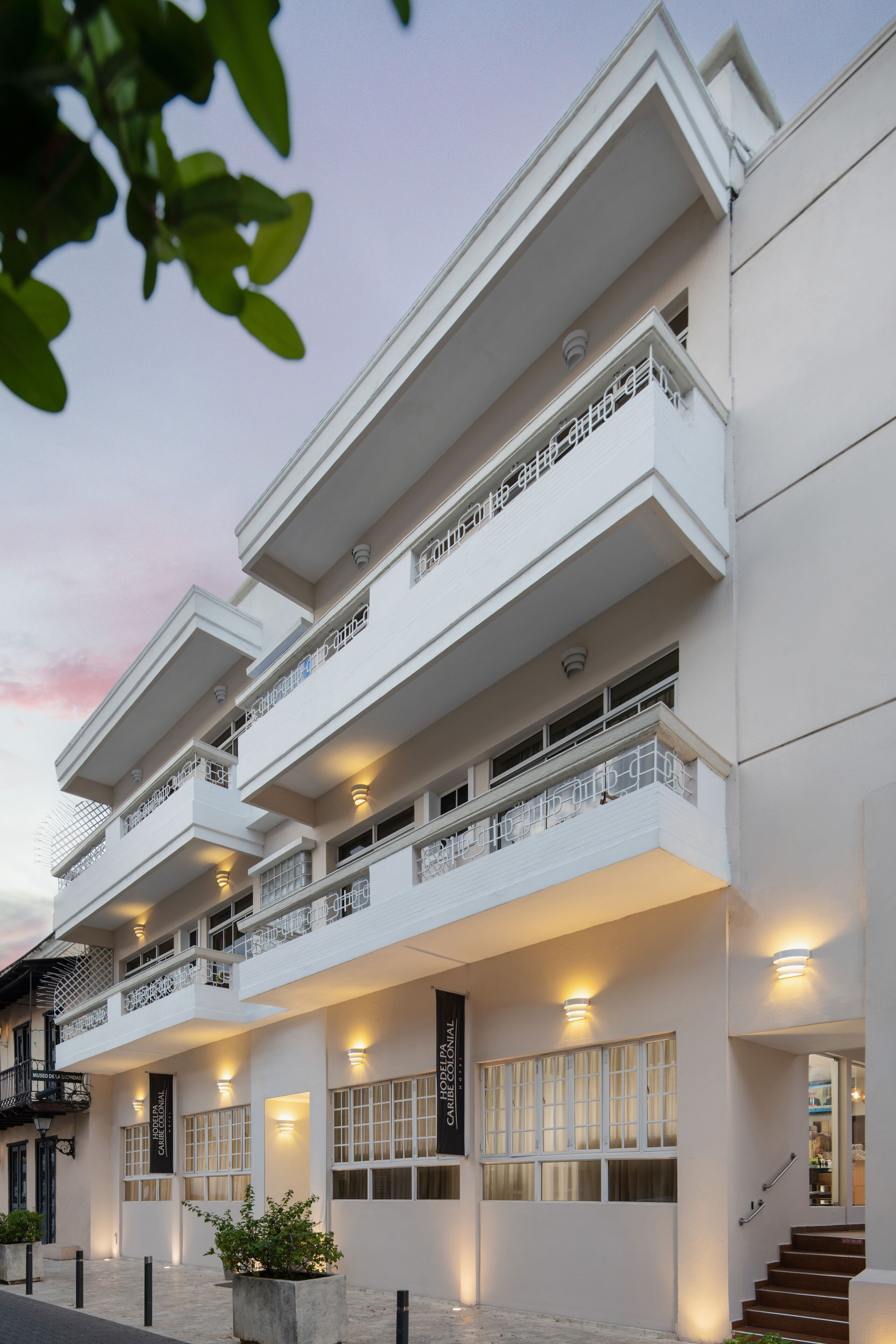 Un hotel de varios pisos con balcones, ventanas amplias y una fachada bien iluminada.