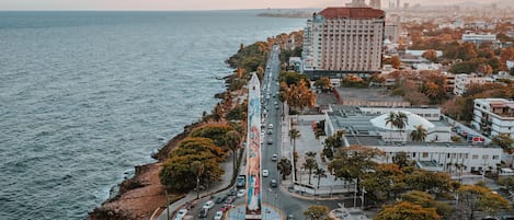Un paysage urbain côtier avec un carrefour bien visible, des bâtiments et une vue sur la mer.