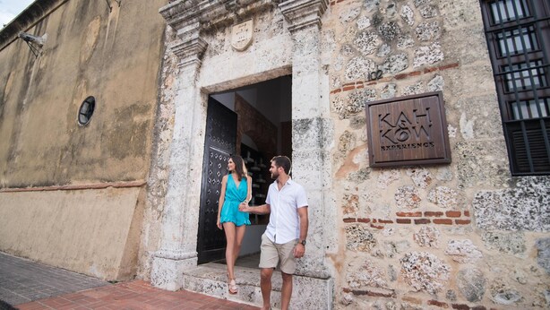 A building with a sign reading "Kah Kow Experiences" and a doorway.