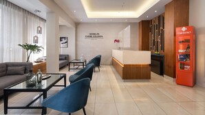 A modern hotel lobby with a reception desk, seating area, and a cigar display.