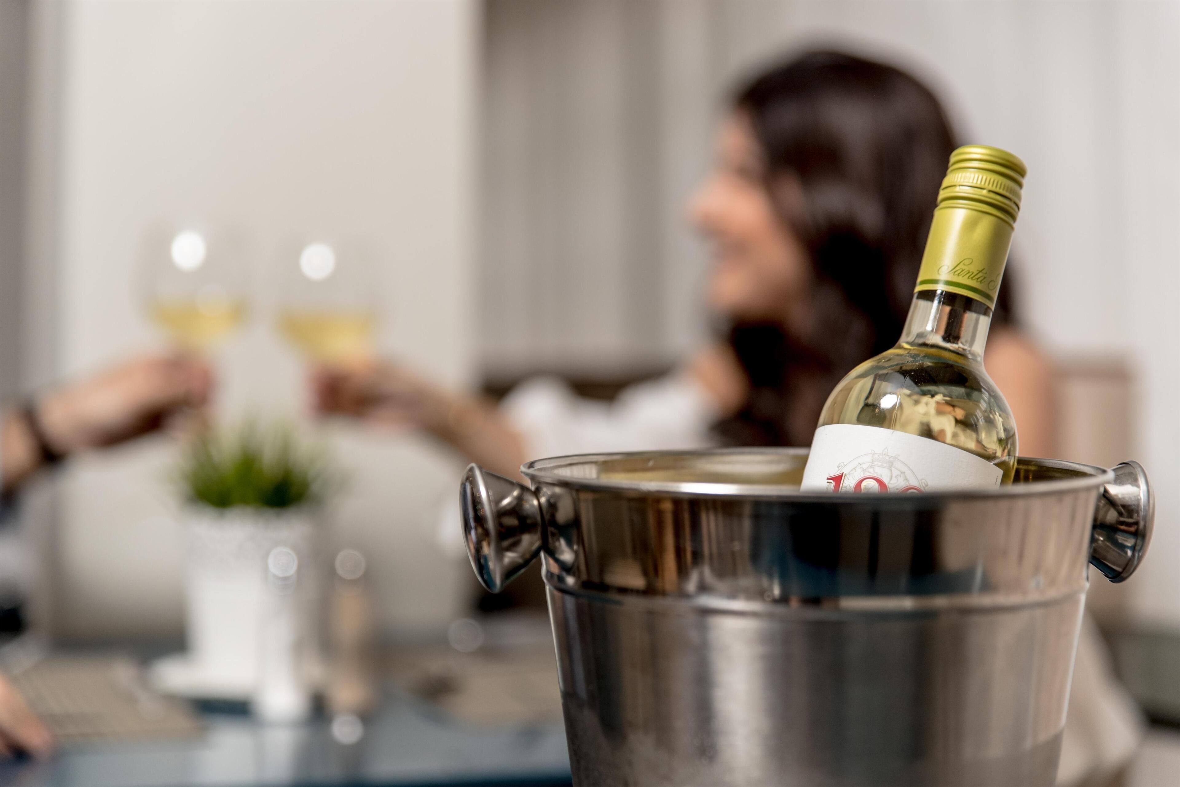 Una botella de vino en un recipiente metálico con etiqueta visible.