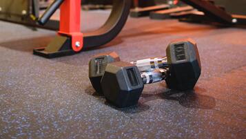A gym with exercise equipment, including dumbbells and a bench.