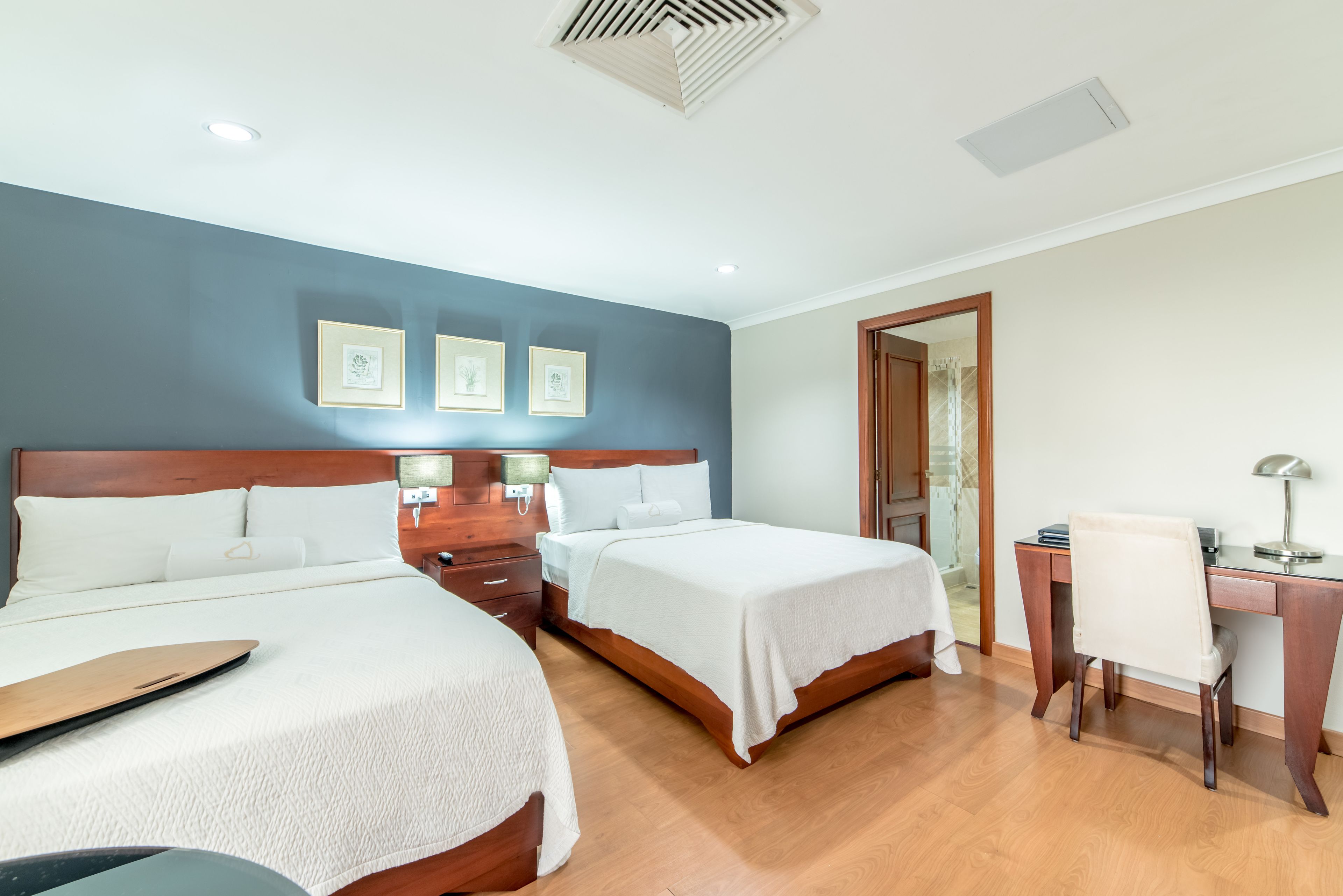Una habitación de hotel con dos camas, un escritorio y una silla.
