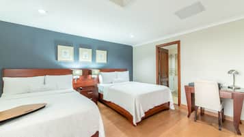 Una habitación de hotel con dos camas, un escritorio y una silla.
