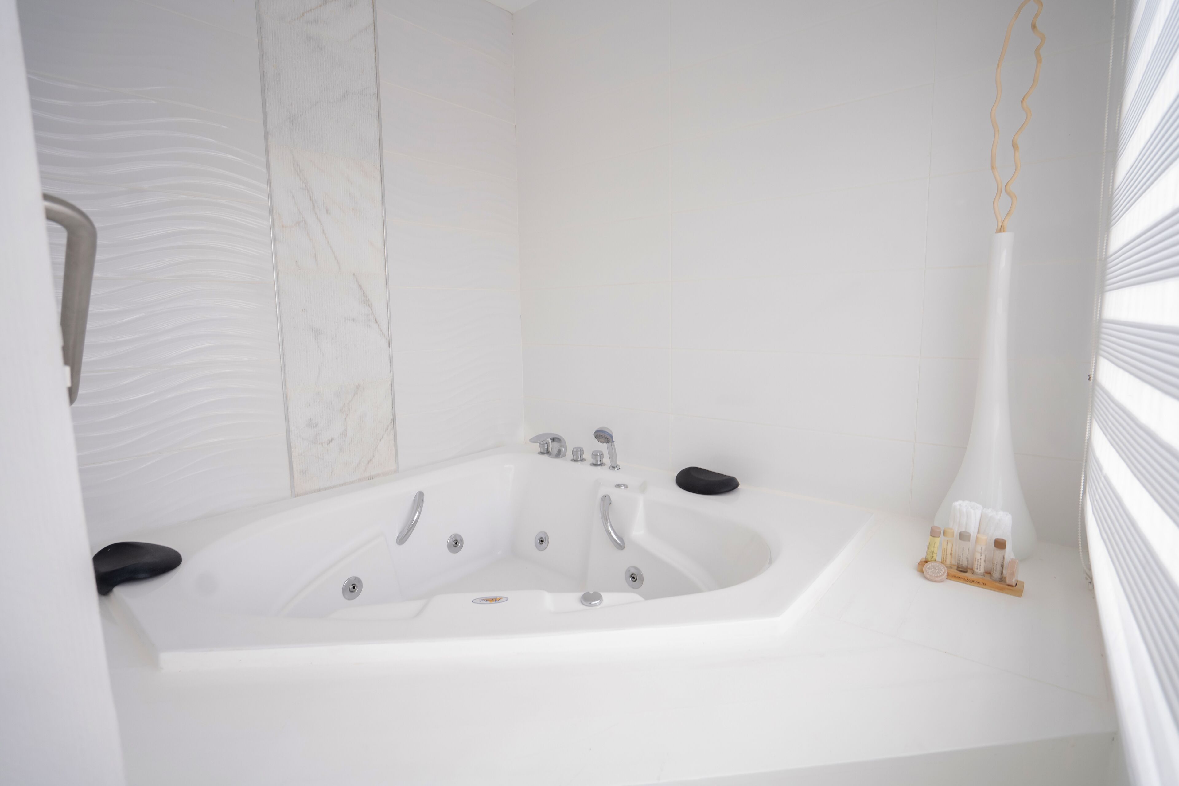 A modern bathroom with a large bathtub, a shower area, and a vanity with a mirror.