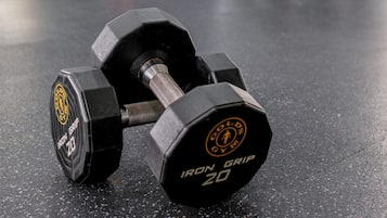 A gym with exercise equipment, including a pair of Iron Grip 20 dumbbells.