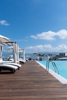 Una piscina al aire libre, sombrillas