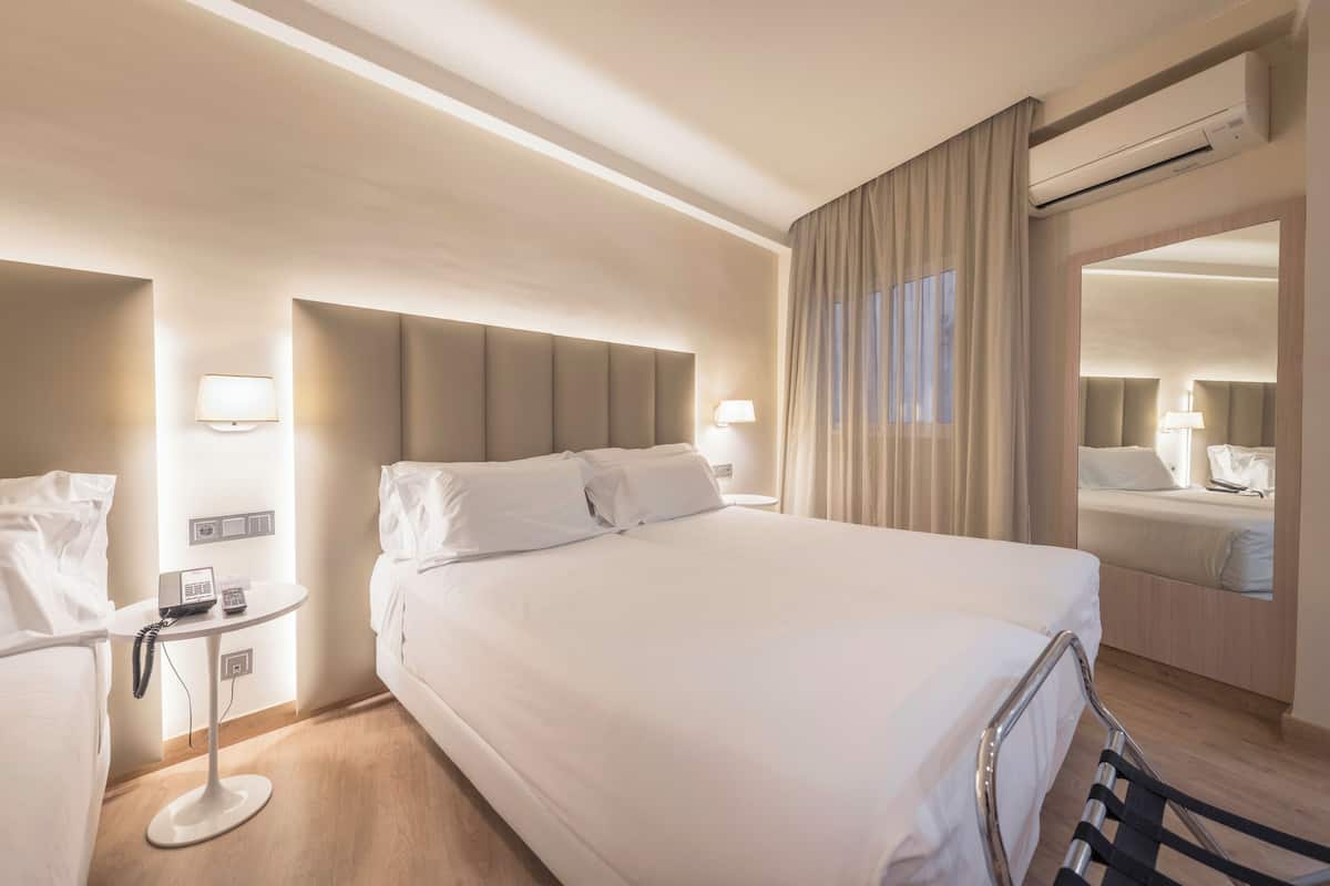Standaard driepersoonskamer | Een minibar, een kluis op de kamer, een bureau, verduisterende gordijnen