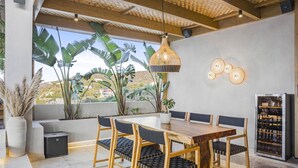 Un'area pranzo con tavolo e sedie in legno, un lampadario e un pensile per il vino.