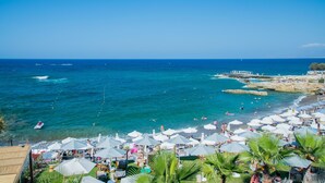 A beach with umbrellas, people, and a boat. - Golden Beach Hotel (Hersonissos)