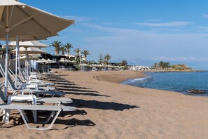 På stranden, solstolar, parasoller och strandhanddukar