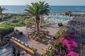 Un resort con piscina, sillas de descanso y zona de barbacoa.