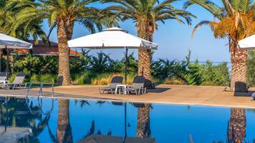 Een buitenzwembad, parasols voor strand/zwembad