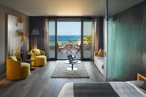 A modern hotel room with a balcony, a bed, a sofa, and two armchairs. - Blue Dolphin Hotel (Polygyros)