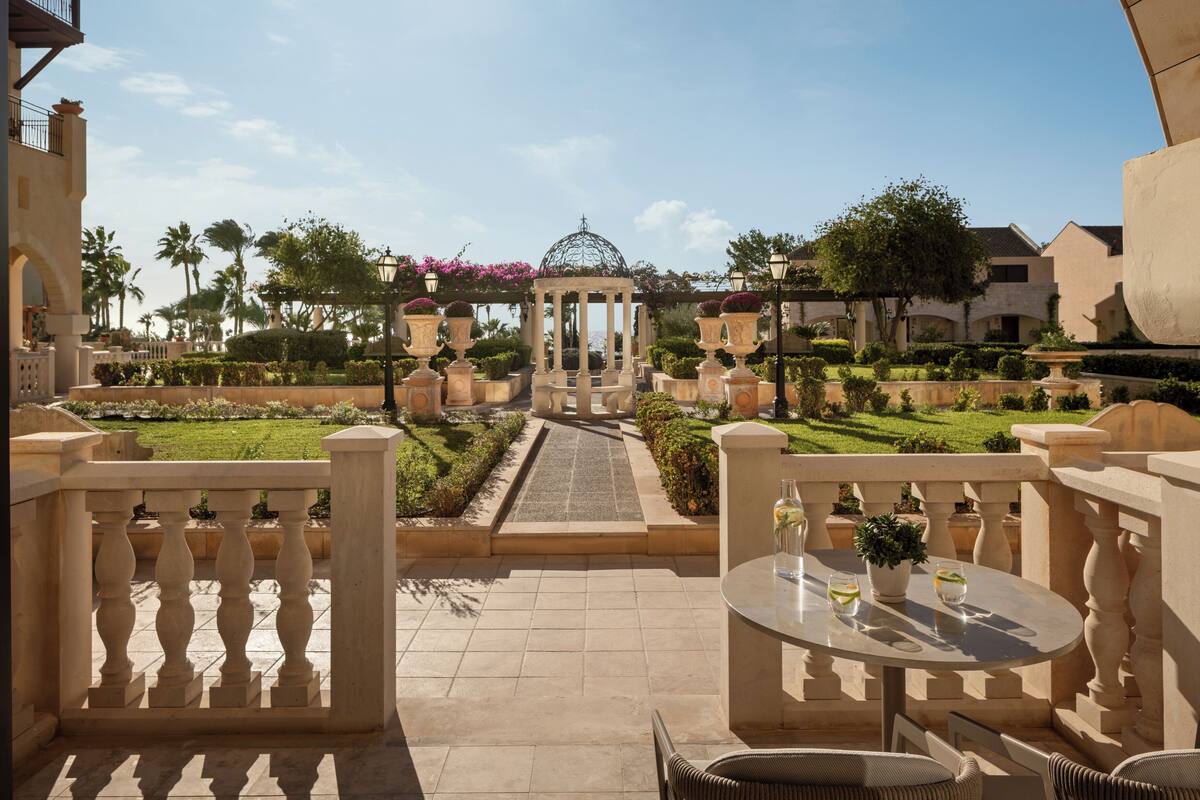 A courtyard with a central gazebo, a fountain, and a seating area with tables and chairs.