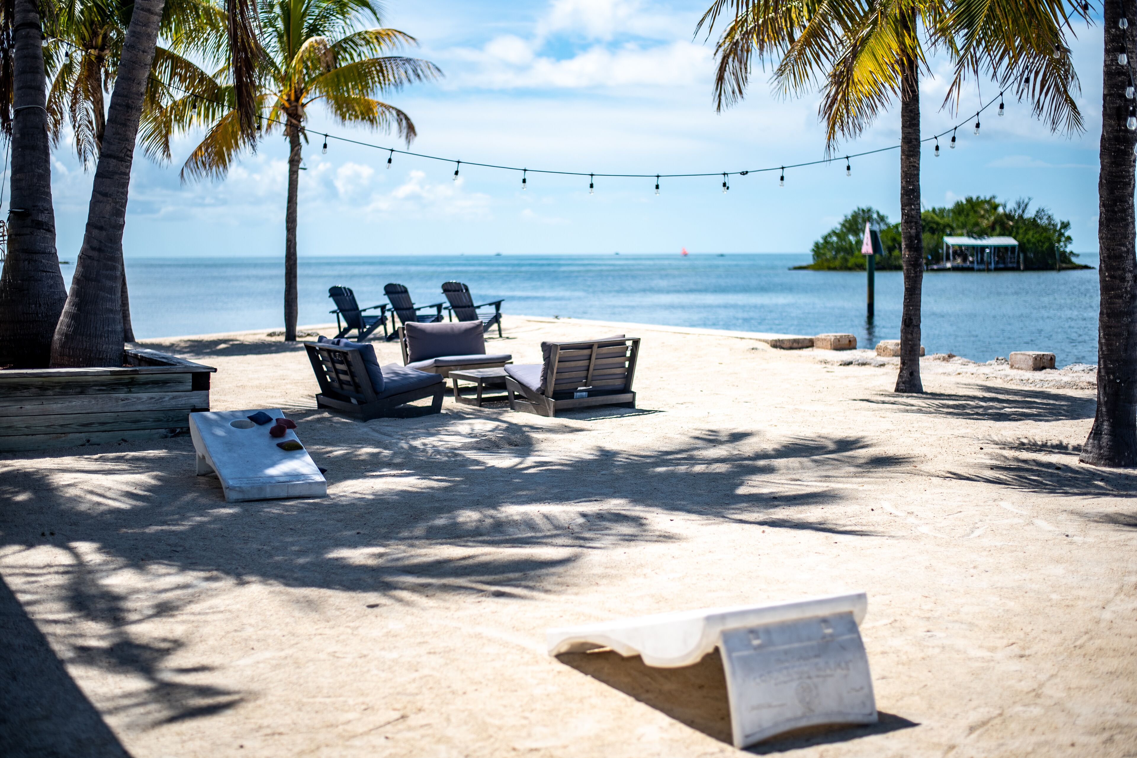 Une plage avec des chaises longues, une terrasse en bois et une vue sur l’océan.