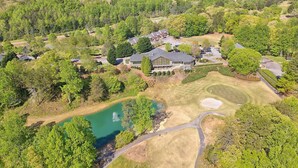 Vista aérea de una zona residencial con casas, un campo de golf y un lago.